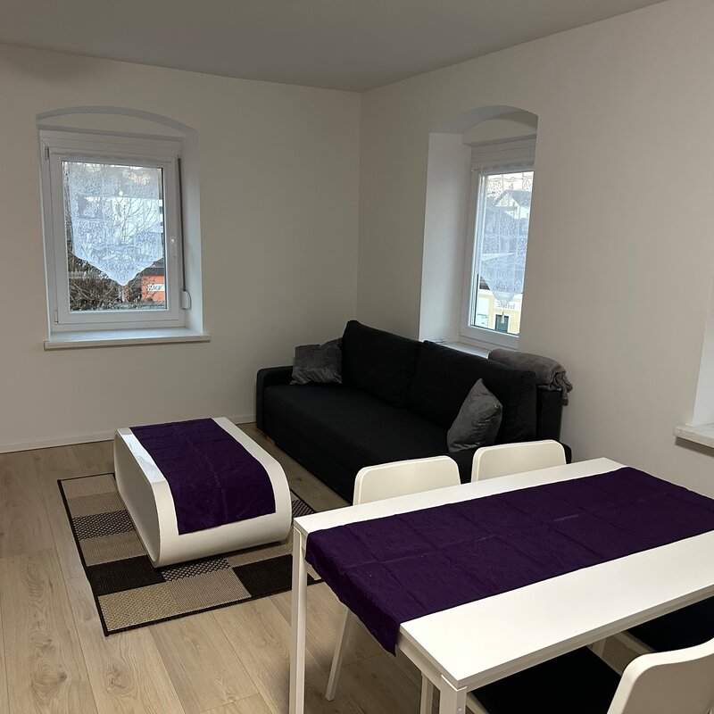 Heller Wohn-Essbereich mit schwarzem Sofa & weißem Esstisch – 3-Zimmer Wohnung, Kurzzeitmiete Niederthalheim, Wohnen auf Zeit 1–6 Monate