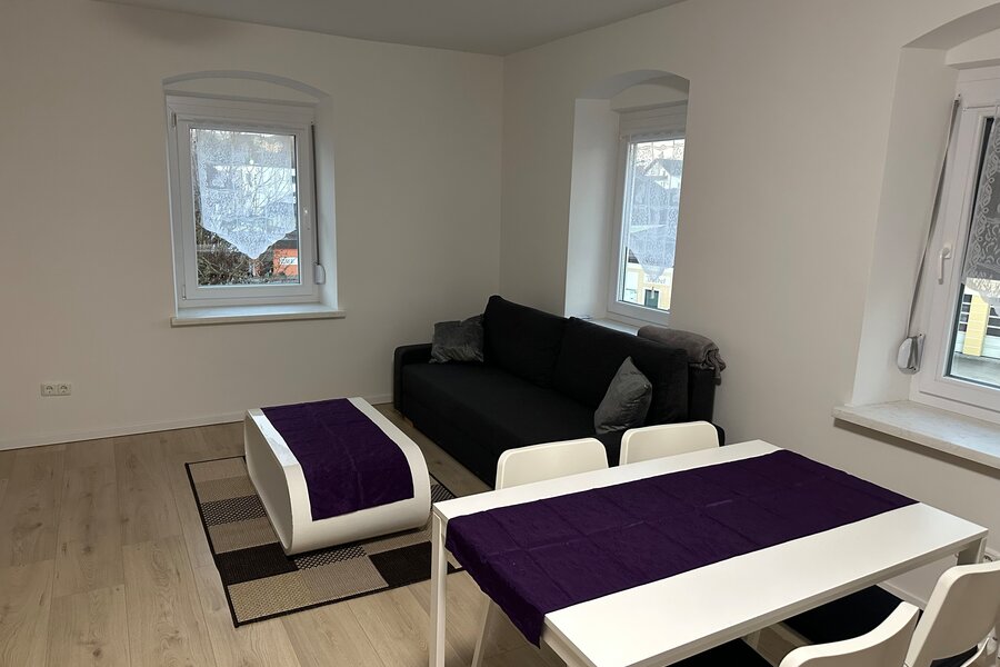 Heller Wohn-Essbereich mit schwarzem Sofa & weißem Esstisch – 3-Zimmer Wohnung, Kurzzeitmiete Niederthalheim, Wohnen auf Zeit 1–6 Monate