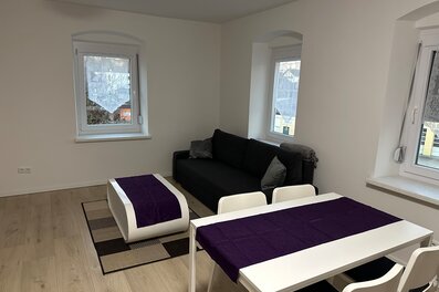 Heller Wohn-Essbereich mit schwarzem Sofa & weißem Esstisch – 3-Zimmer Wohnung, Kurzzeitmiete Niederthalheim, Wohnen auf Zeit 1–6 Monate