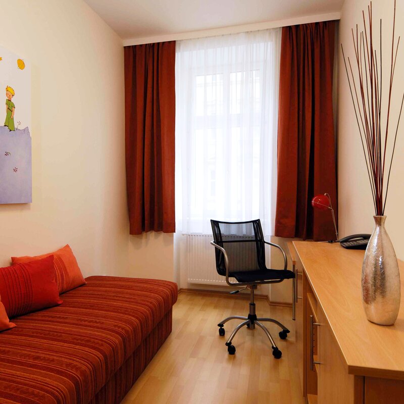 Furnished room with sofa & desk – 3-room apartment, short-term rental Vienna, temporary housing 1 to 6 months