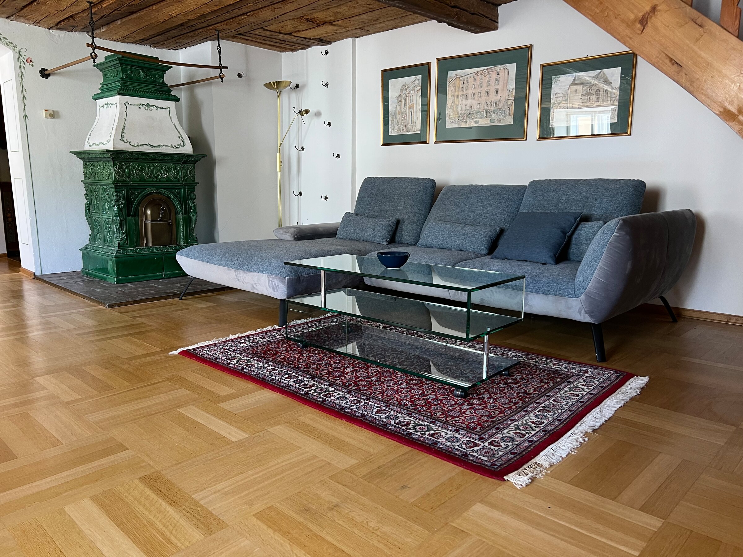 Wohnzimmer mit grünem Kachelofen & Holzbalkendecke – 3-Zimmer Wohnung, Kurzzeitmiete & Wohnen auf Zeit für 1 bis 6 Monate, Salzburg