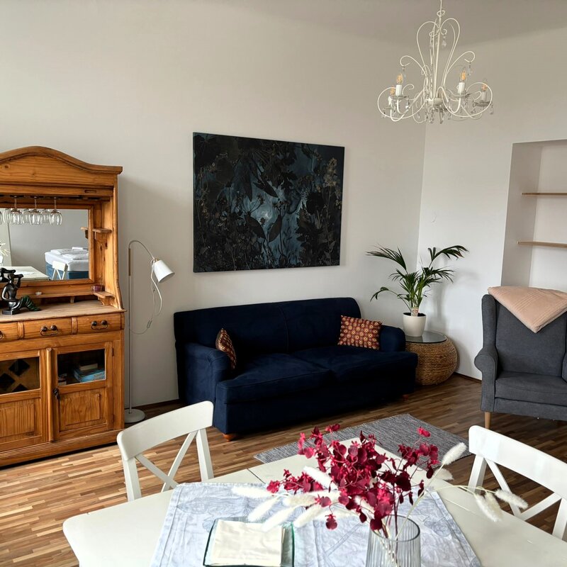 Wohnzimmer mit Holzmöbeln & blauem Sofa – 2-Zimmer Wohnung, Kurzzeitmiete Wien, Wohnen auf Zeit 1 bis 6 Monate