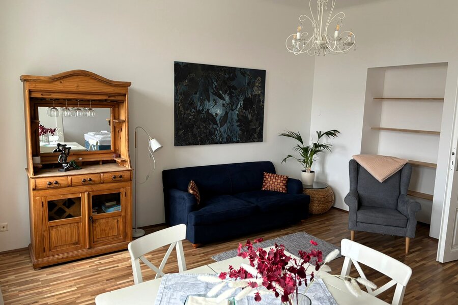 Wohnzimmer mit Holzmöbeln & blauem Sofa – 2-Zimmer Wohnung, Kurzzeitmiete Wien, Wohnen auf Zeit 1 bis 6 Monate