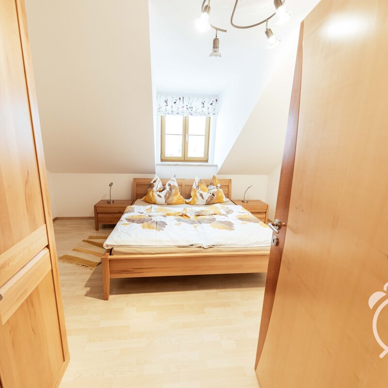 Bright bedroom with wood furniture – 3-room apartment for short-term rental & temporary housing for 1 to 6 months in Henndorf