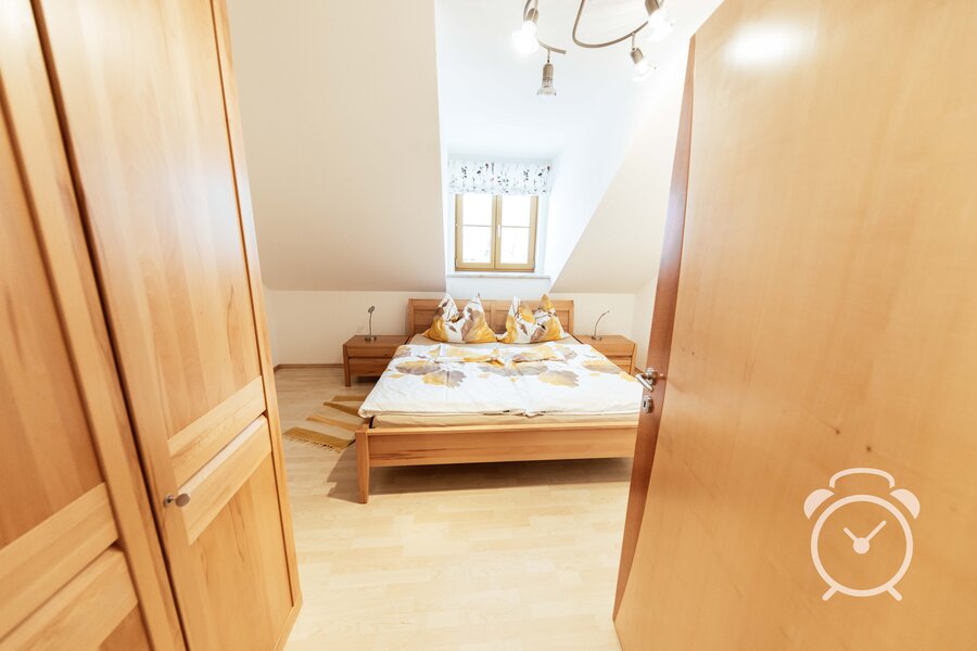 Bright bedroom with wood furniture – 3-room apartment for short-term rental & temporary housing for 1 to 6 months in Henndorf