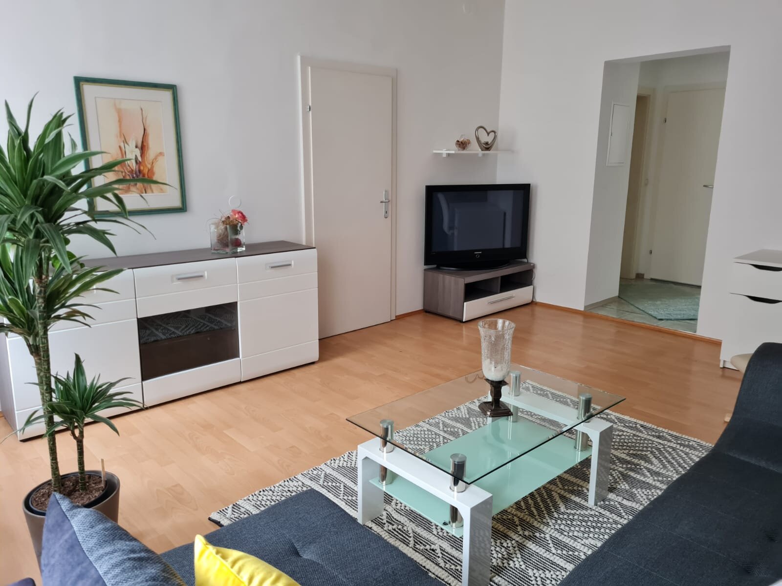 Helles Wohnzimmer mit Glasstisch & TV – 2-Zimmer Wohnung, Kurzzeitmiete & Wohnen auf Zeit für 1 bis 6 Monate in Graz