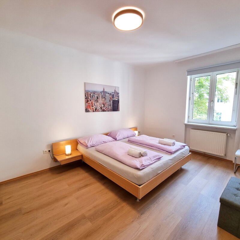 Helles Schlafzimmer mit Doppelbett & Parkettboden – 2-Zimmer-Wohnung zur Kurzzeitmiete, Wohnen auf Zeit für 1 bis 6 Monate in Wien