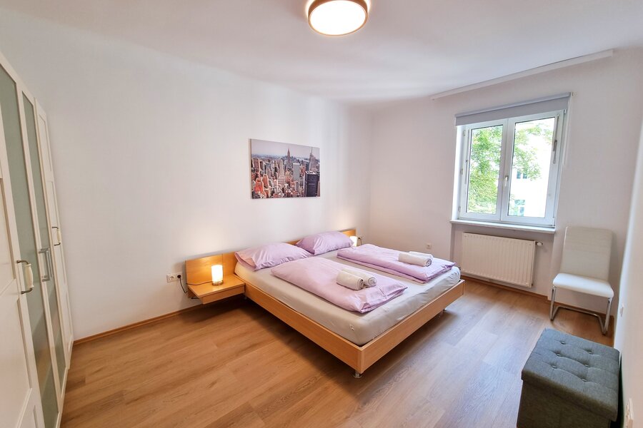 Helles Schlafzimmer mit Doppelbett & Parkettboden – 2-Zimmer-Wohnung zur Kurzzeitmiete, Wohnen auf Zeit für 1 bis 6 Monate in Wien