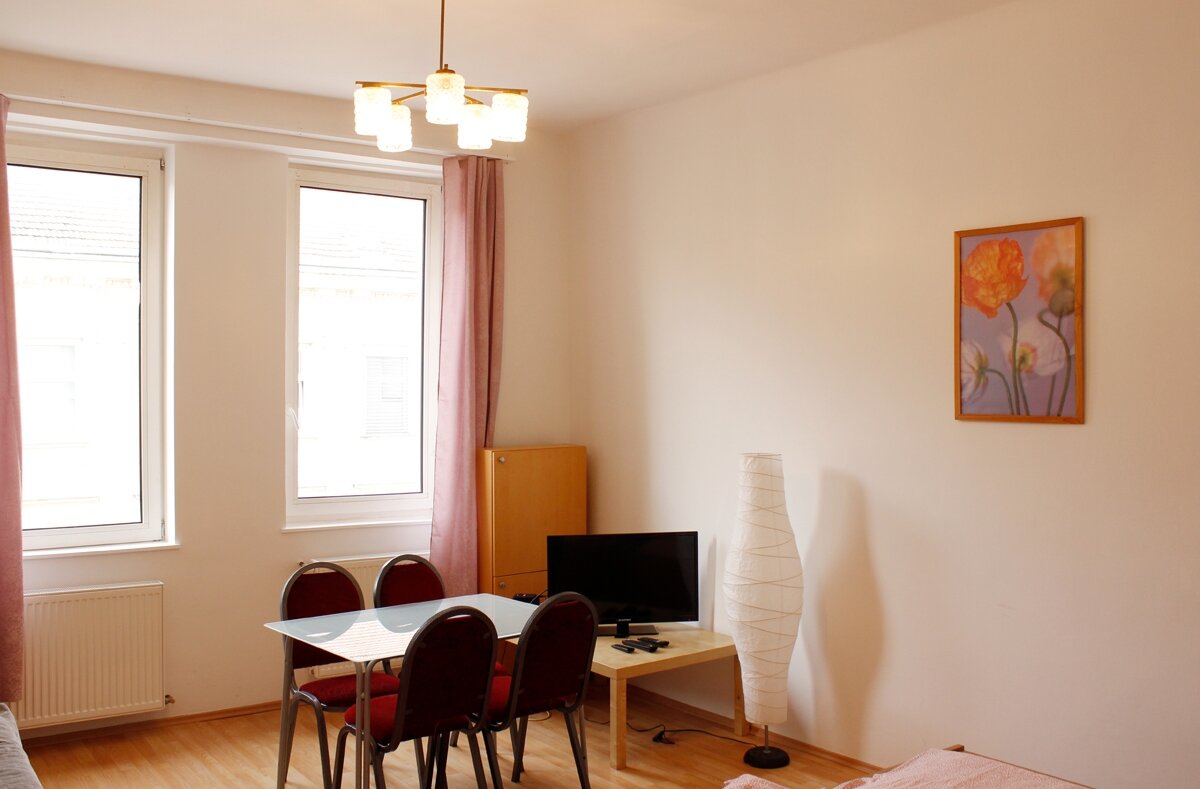 Helles Wohnzimmer mit Esstisch & TV – 1-Zimmer Wohnung zur Kurzzeitmiete, Wohnen auf Zeit für 1 bis 6 Monate in Wien