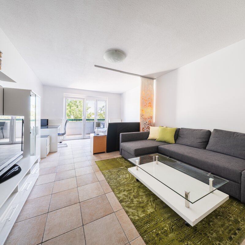 Helles Wohnzimmer mit Couch & Balkon – 1-Zimmer-Wohnung zur Kurzzeitmiete & Wohnen auf Zeit in Wien, 1 bis 6 Monate