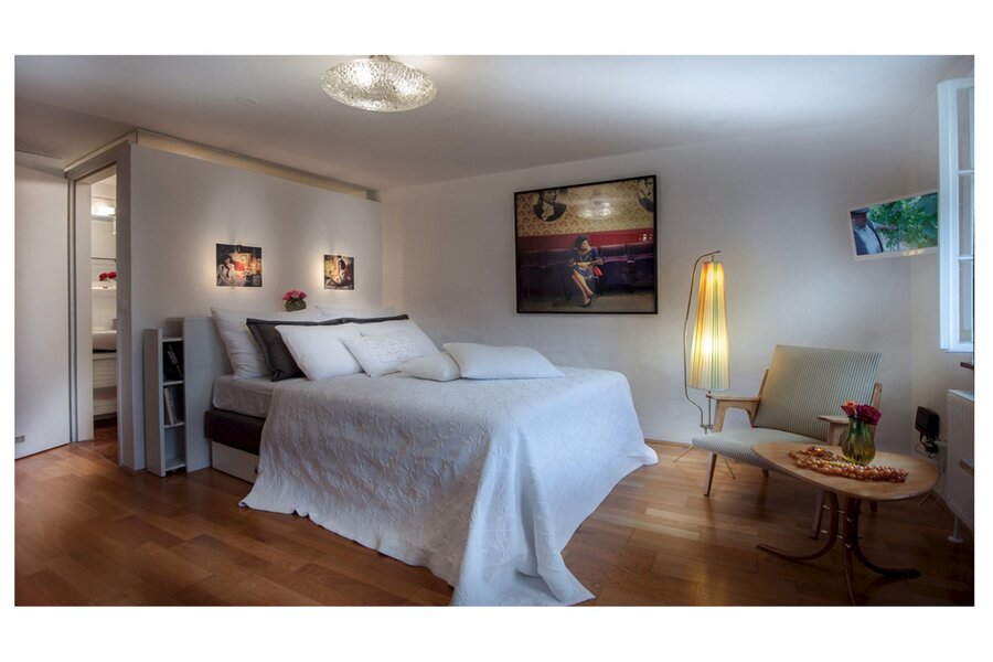 Bright bedroom with double bed & artwork – 1-room apartment, short-term rental, temporary housing for 1 to 6 months, Salzburg