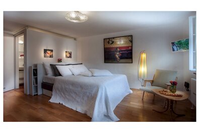 Bright bedroom with double bed & artwork – 1-room apartment, short-term rental, temporary housing for 1 to 6 months, Salzburg