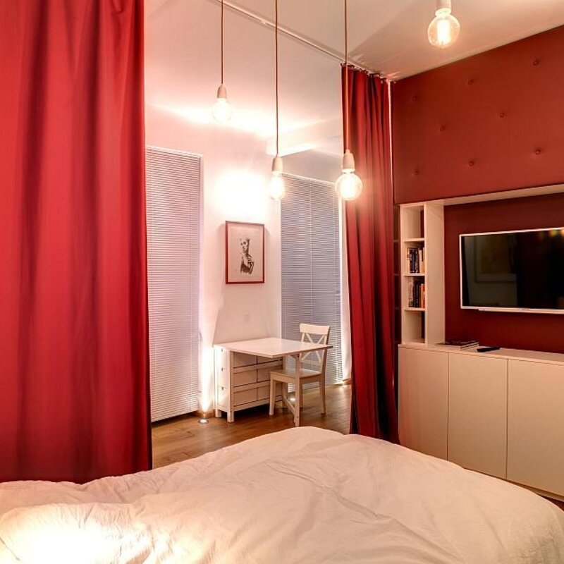 Stilvolles Schlafzimmer mit rotem Akzent & TV – 1-Zimmer Wohnung zur Kurzzeitmiete, Wohnen auf Zeit 1 bis 6 Monate, Wien