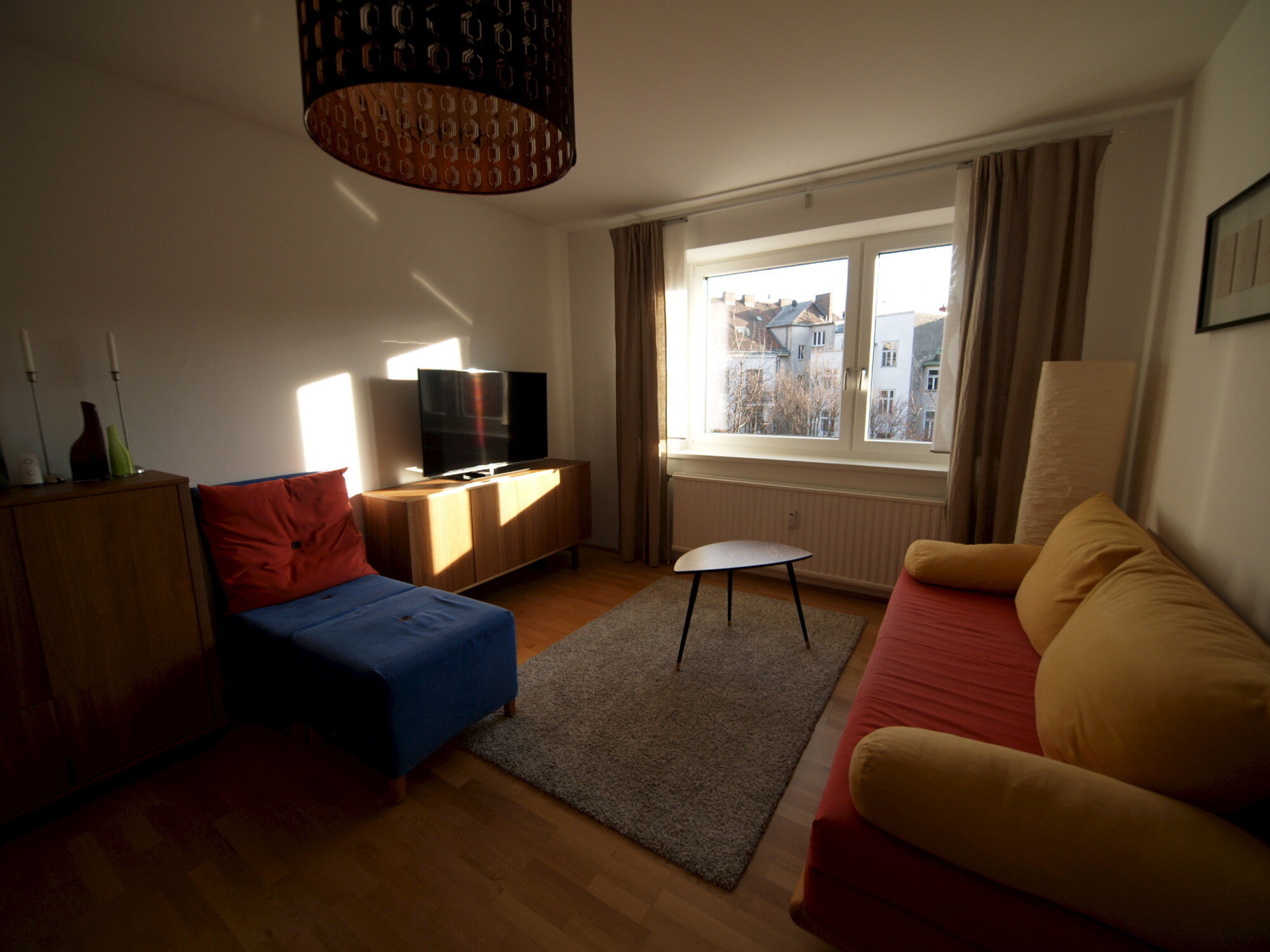 Wohnzimmer mit Ausziehcouch und Esstisch.