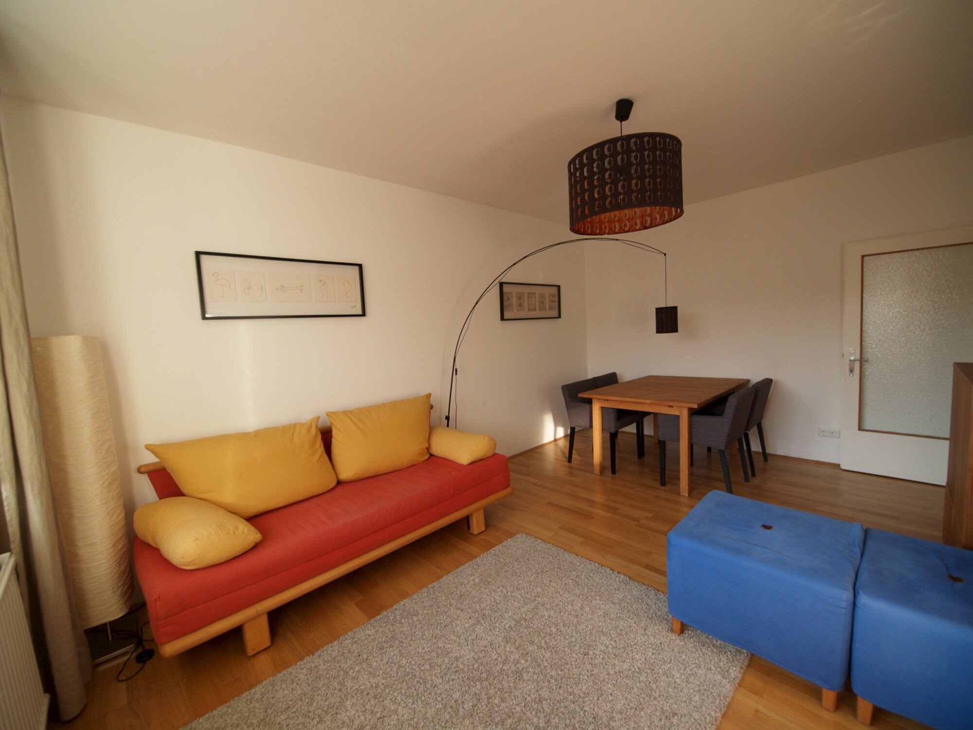 Wohnzimmer mit Ausziehcouch und Esstisch.