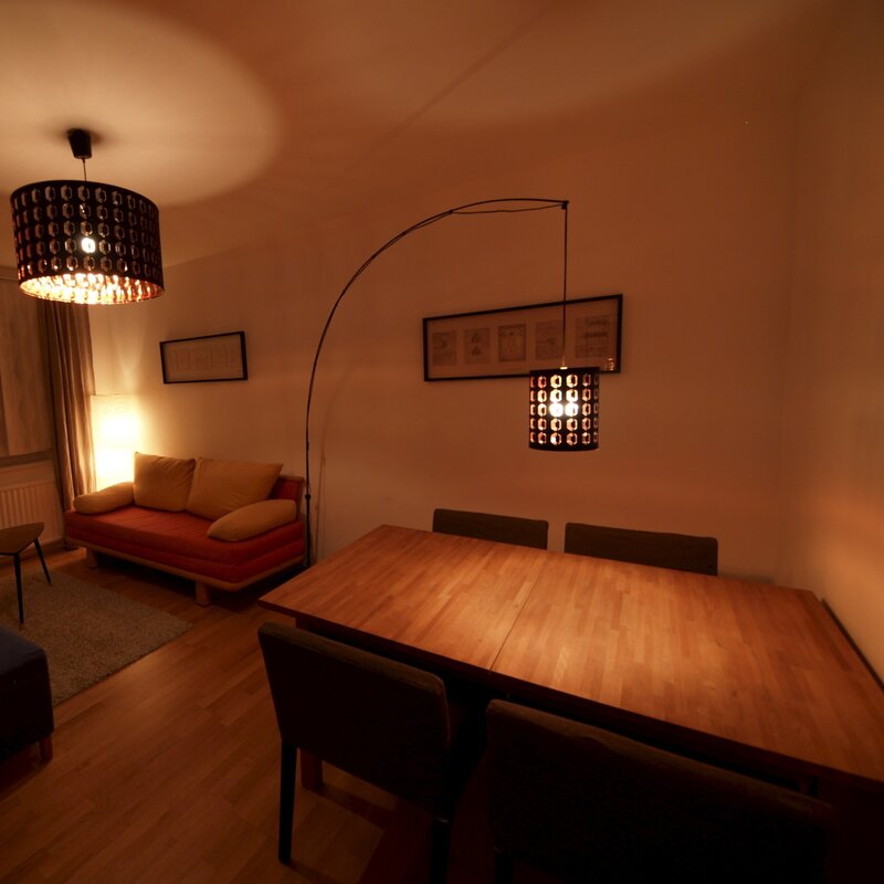 Wohnzimmer mit Ausziehcouch und Esstisch.