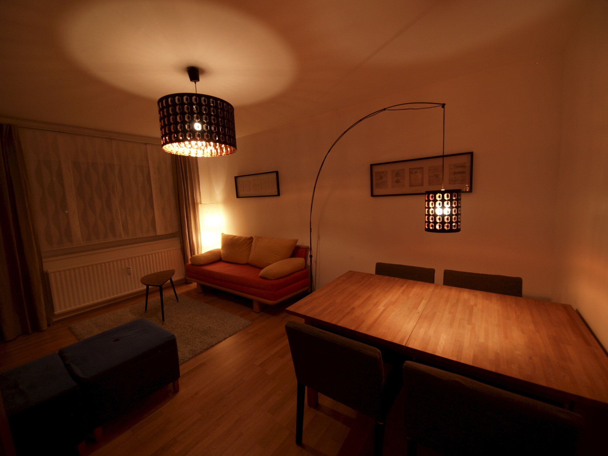 Wohnzimmer mit Ausziehcouch und Esstisch.