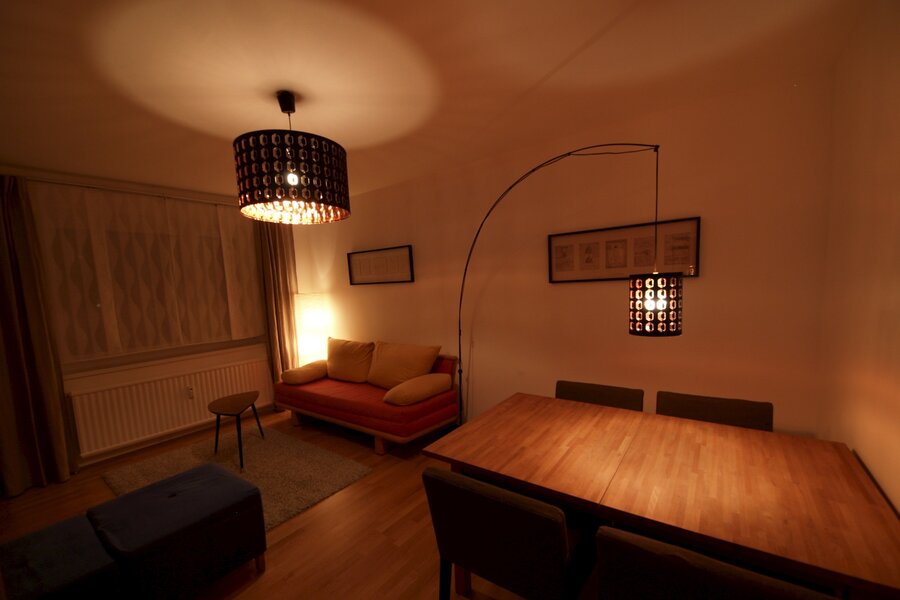 Wohnzimmer mit Ausziehcouch und Esstisch.