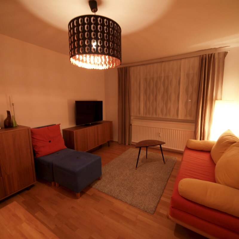 Wohnzimmer mit Ausziehcouch und Esstisch.