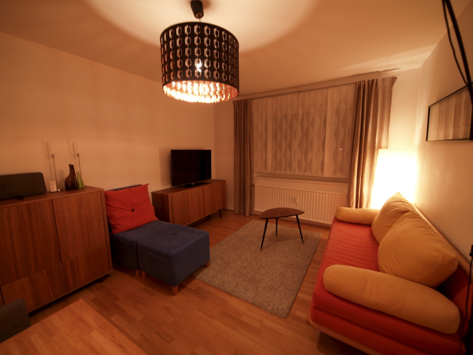 Wohnzimmer mit Ausziehcouch und Esstisch.