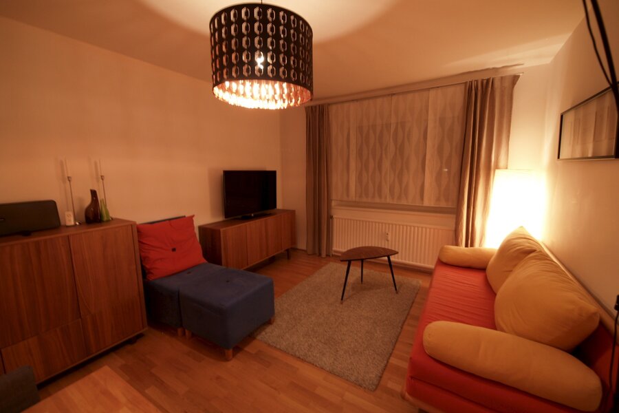 Wohnzimmer mit Ausziehcouch und Esstisch.