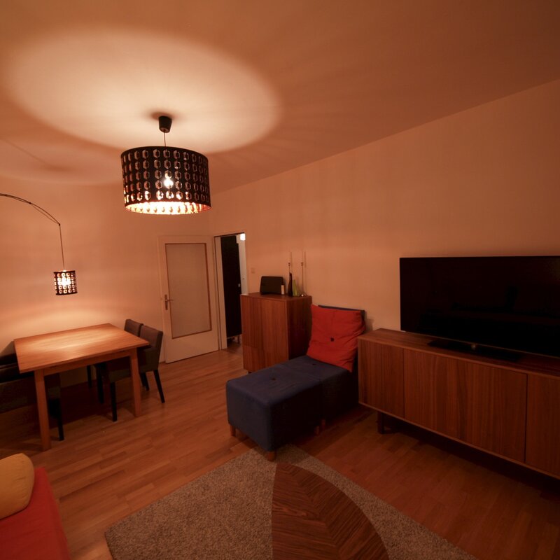 Wohnzimmer mit Ausziehcouch und Esstisch.