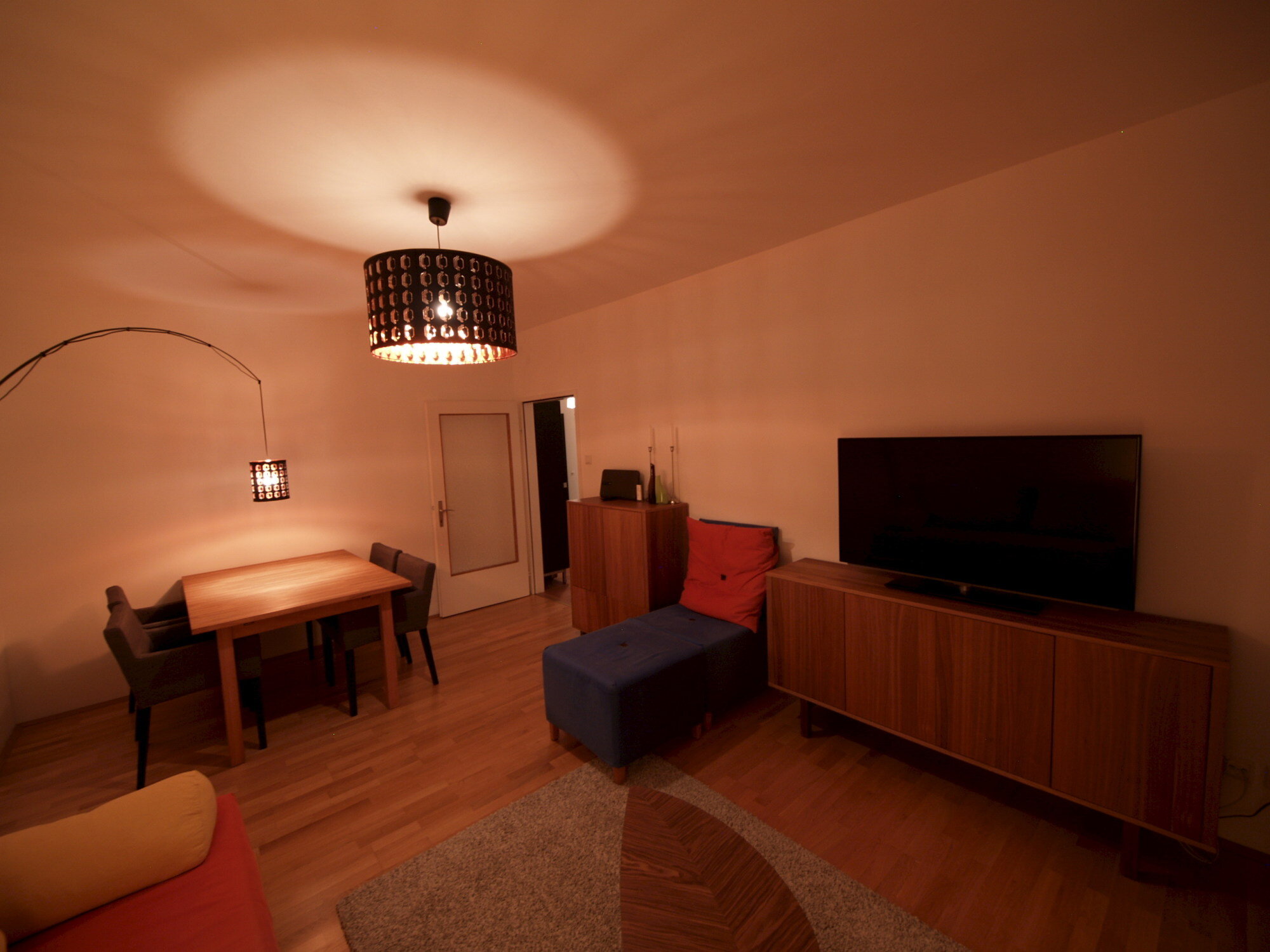 Wohnzimmer mit Ausziehcouch und Esstisch.