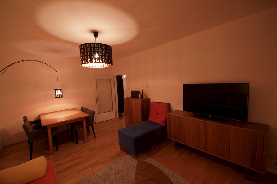 Wohnzimmer mit Ausziehcouch und Esstisch.