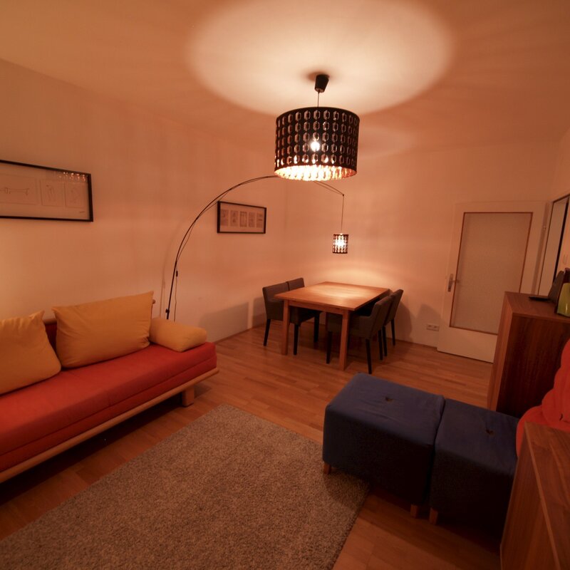 Wohnzimmer mit Ausziehcouch und Esstisch.