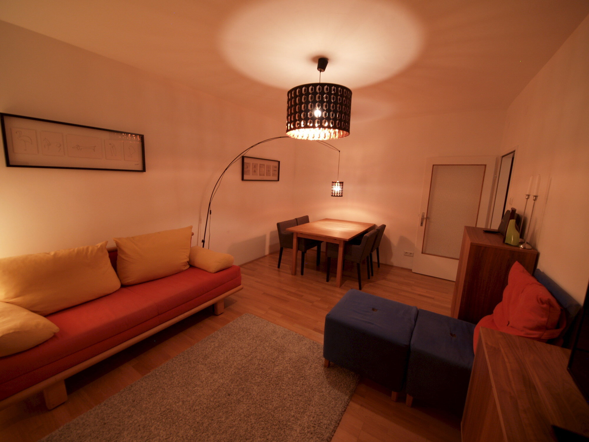 Wohnzimmer mit Ausziehcouch und Esstisch.