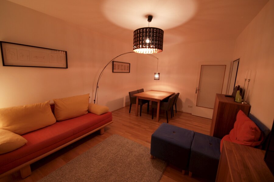 Wohnzimmer mit Ausziehcouch und Esstisch.