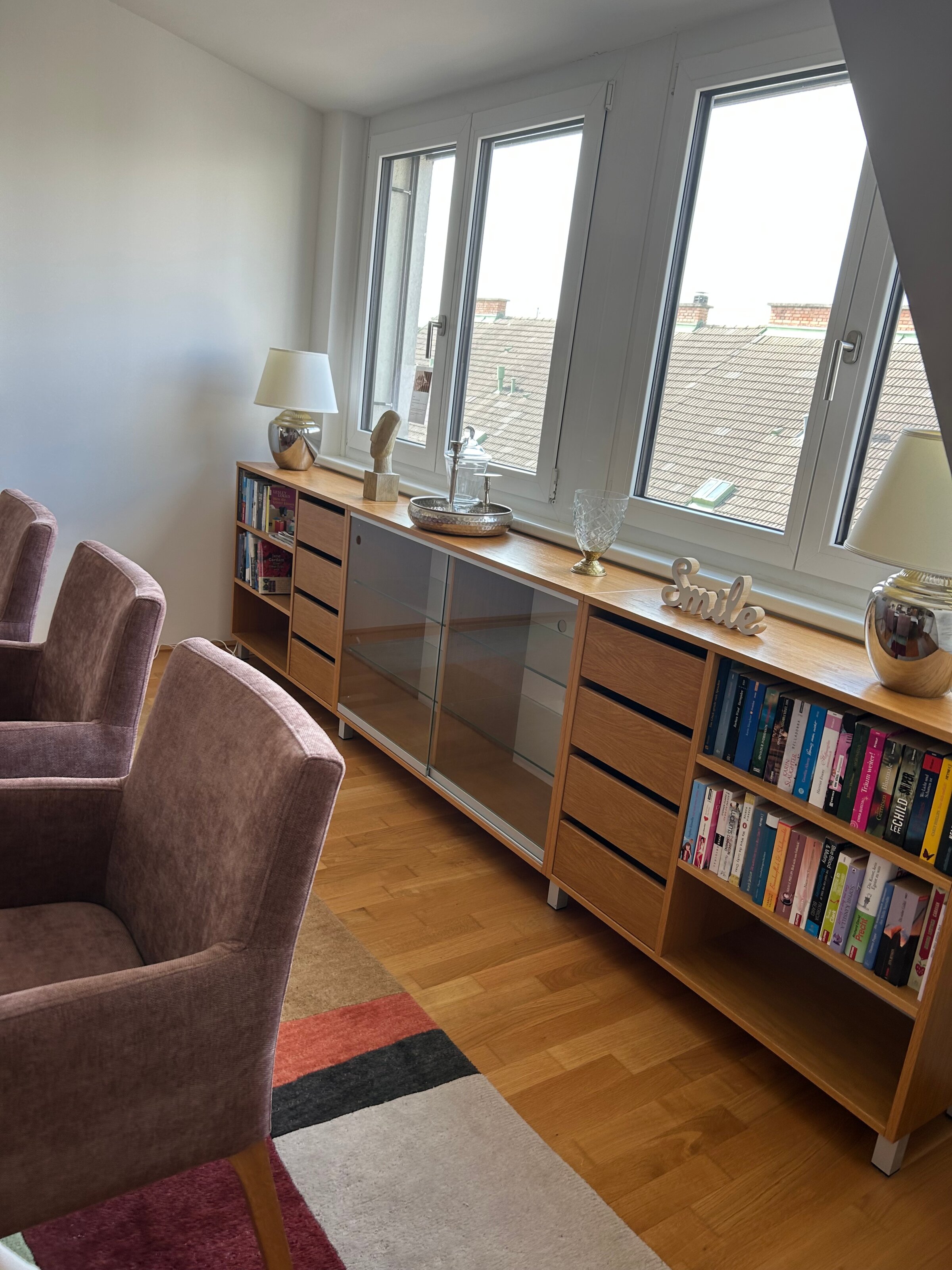 Bright living room with armchairs & bookshelf – 3-room apartment for short-term rental & temporary housing for 1 to 6 months in Schwechat