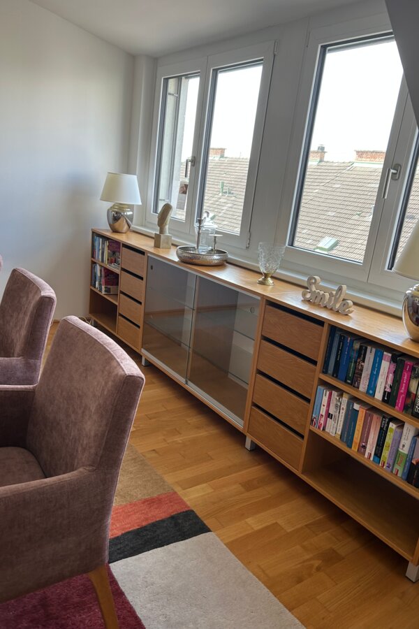 Bright living room with armchairs & bookshelf – 3-room apartment for short-term rental & temporary housing for 1 to 6 months in Schwechat