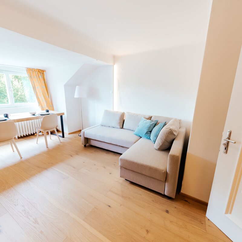 Heller Wohnbereich mit Sofa & Esstisch – 2-Zimmer-Wohnung zur Kurzzeitmiete & Wohnen auf Zeit für 1 bis 6 Monate in Salzburg