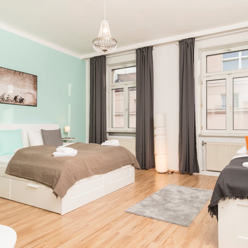 Helles Schlafzimmer mit zwei Betten, Parkettboden & Kronleuchter – 3-Zimmer Wohnung zur Kurzzeitmiete Wien, 1 bis 6 Monate