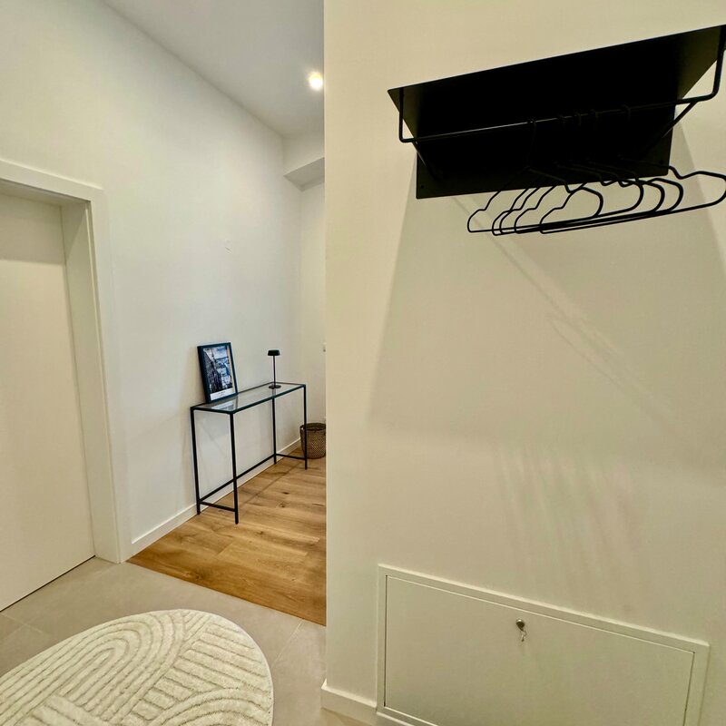 Der einladende Eingangsbereich und Flur bieten ausreichend Platz, um in Ruhe anzukommen und Ihre Kleidung sowie Gepäck bequem abzulegen. Die moderne Einrichtung und die stilvollen Details schaffen eine angenehme Atmosphäre.