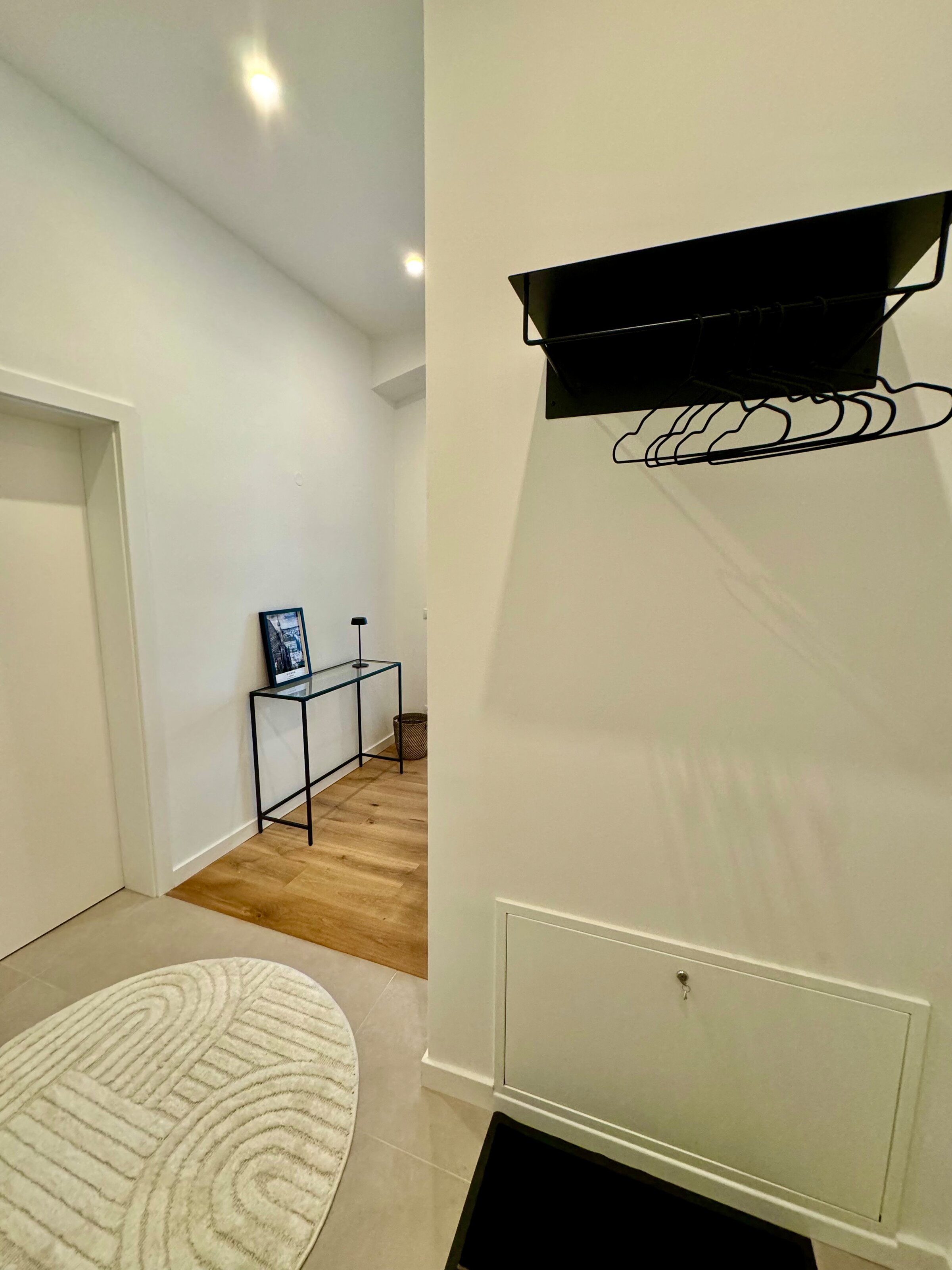 Der einladende Eingangsbereich und Flur bieten ausreichend Platz, um in Ruhe anzukommen und Ihre Kleidung sowie Gepäck bequem abzulegen. Die moderne Einrichtung und die stilvollen Details schaffen eine angenehme Atmosphäre.