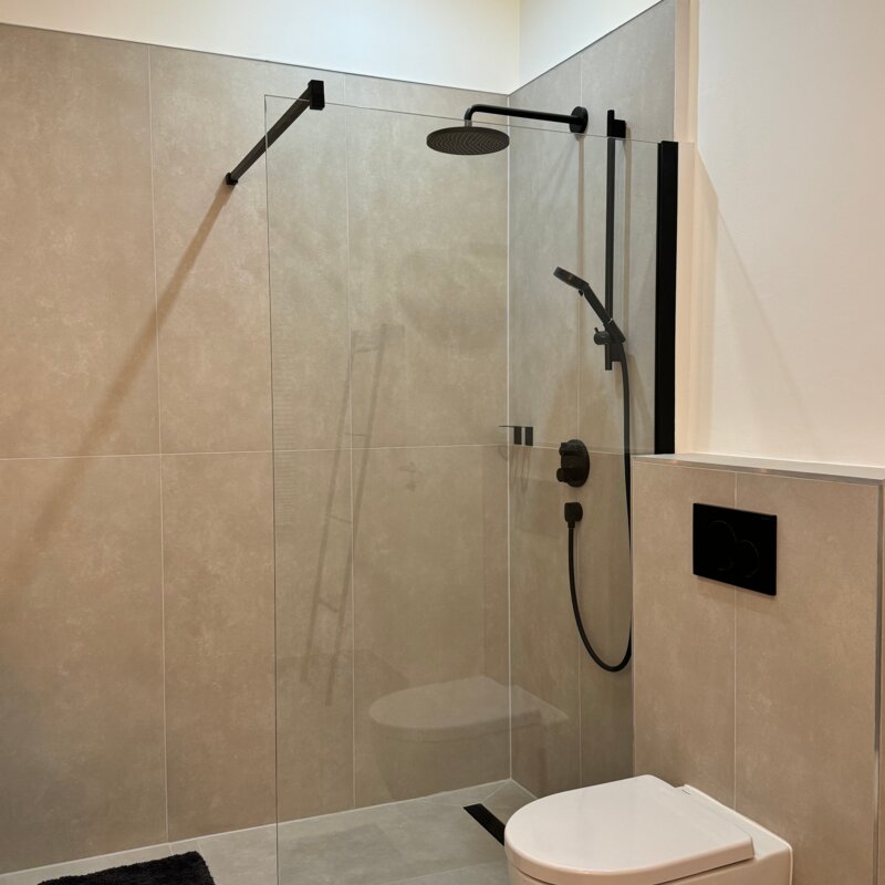 Die geräumige und stilvolle Dusche im Badezimmer bietet höchsten Komfort und moderne Armaturen. Die klaren Linien und das elegante Design sorgen für ein luxuriöses Duscherlebnis.
