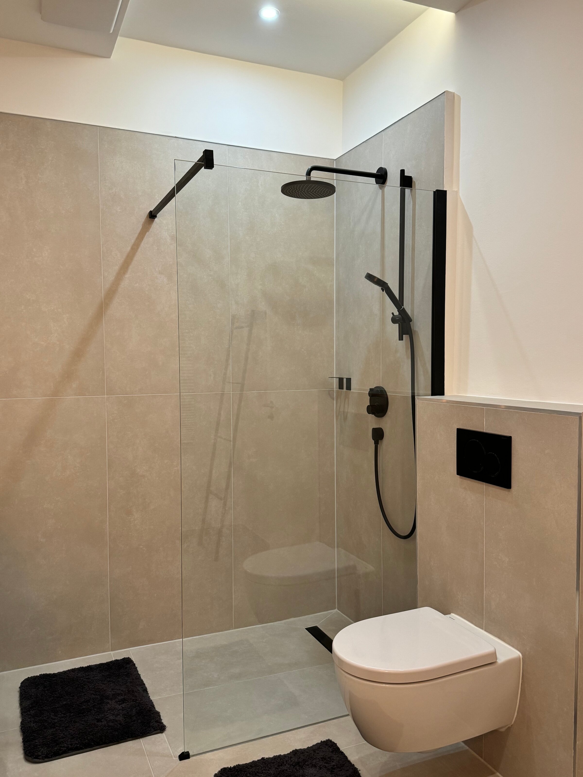 Die geräumige und stilvolle Dusche im Badezimmer bietet höchsten Komfort und moderne Armaturen. Die klaren Linien und das elegante Design sorgen für ein luxuriöses Duscherlebnis.