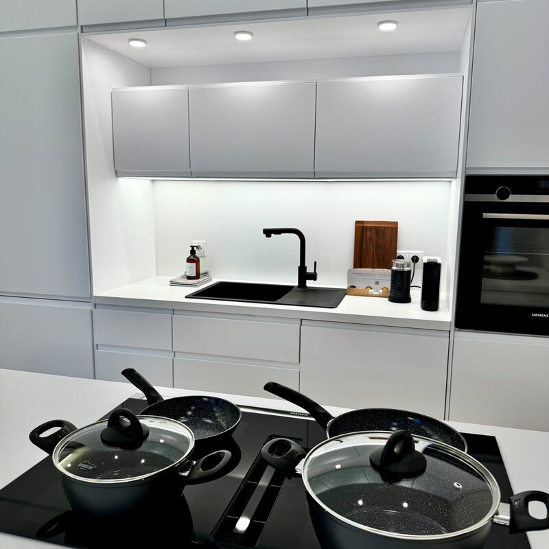 The fully equipped kitchen features high-quality appliances and all necessary utensils. The minimalist design and clean lines create an elegant and functional workspace.