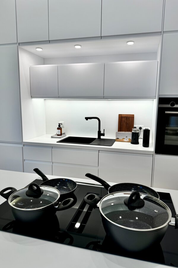 Die voll ausgestattete Küche ist mit hochwertigen Geräten und allen notwendigen Utensilien ausgestattet. Das minimalistische Design und die klaren Linien schaffen eine elegante und funktionale Arbeitsumgebung.