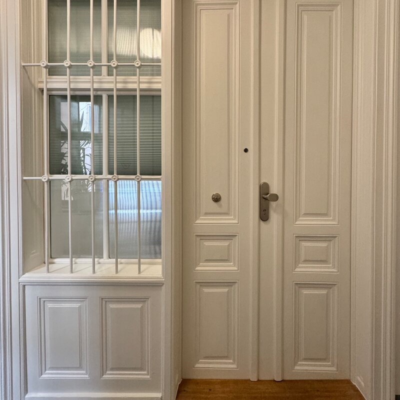 Die Eingangstür der Wohnung von außen. Das Fenster aus geriffeltem Glas zum Hausflur lässt Licht in die Wohnung und kann mit einem Rollo verdunkelt werden. Es sorgt zusätzlich für ausreichenden Sichtschutz und gewährleistet Privatsphäre.