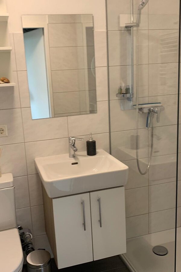 Badezimmer mit Dusche, Waschbecken, Toilette, Aufbewahrung