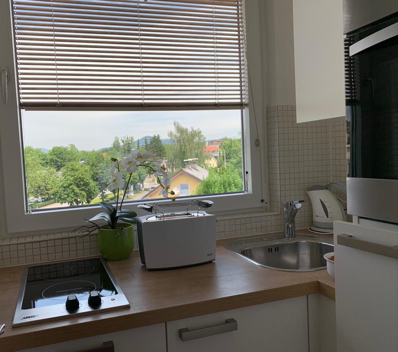 kleine, abgeschlossene Küche mit Kochfeld, Backrohr, Kühlschrank, Nespressomaschine, Wasserkocher und div. Geschirr