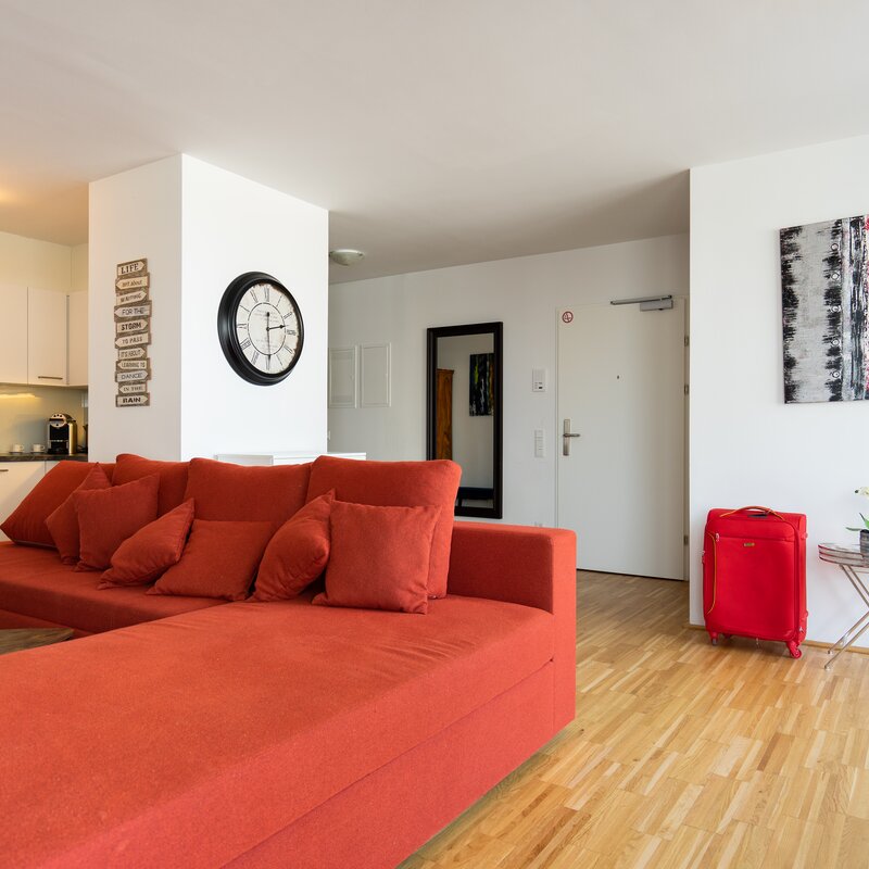 Bright living kitchen, red sofa – 4-room apartment, short-term rental & temporary housing, 1 to 6 months, Vienna