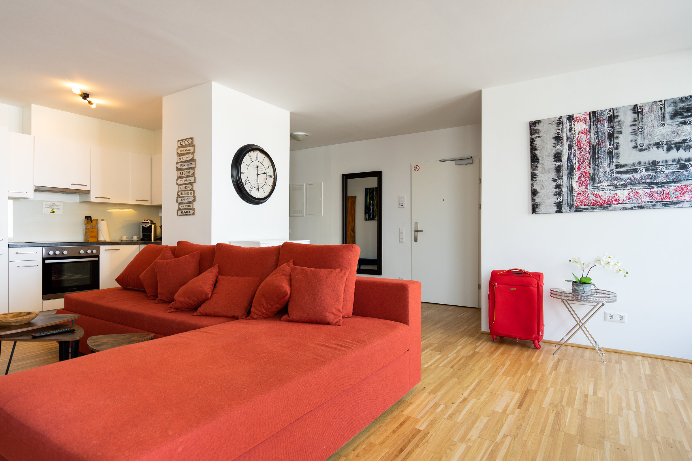 Bright living kitchen, red sofa – 4-room apartment, short-term rental & temporary housing, 1 to 6 months, Vienna