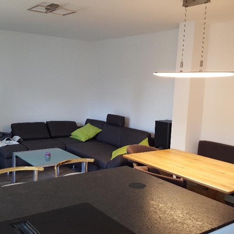 Im Wohnbereich befindet sich eine großzügige Couch und ein großer Flachbildfernseher.