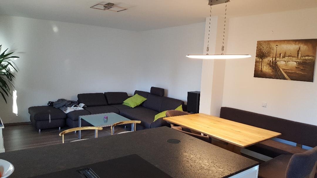 Im Wohnbereich befindet sich eine großzügige Couch und ein großer Flachbildfernseher.