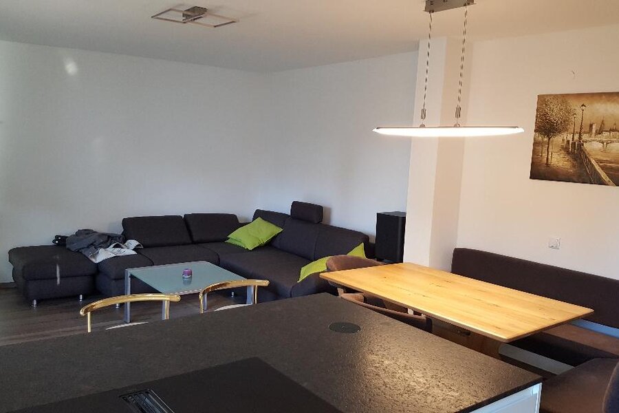 Im Wohnbereich befindet sich eine großzügige Couch und ein großer Flachbildfernseher.