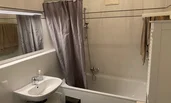 Badezimmer mit Waschbecken, Badewanne, Waschmaschine | © CH